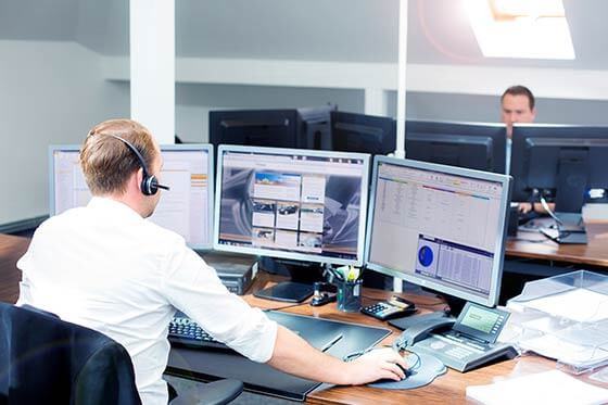 Zwei Disponenten sitzen vor Bildschirmen.